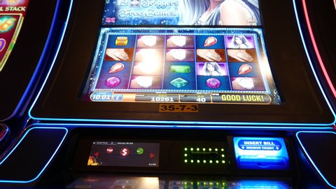 COQUITLAM , British Columbia / Canada - 05 31 2019: Coquitlam, BC, Canada - May 31, 2019 : Motion of people playing slot machine inside Casino, focus on screen with 4k resolution