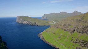 4K aerial - a bird's eye view video (Ultra High Definition) of Eidi village. Amazing morning scene of Eysturoy island with Eidiskollur cliffs on background, Faroe Islands, Denmark, Europe. 