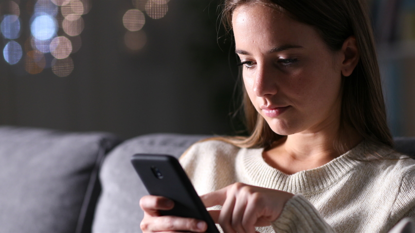 Excited woman checking good news on smart phone sitting on a couch at home in the night Royalty-Free Stock Footage #1037775281