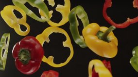 Top view of chopped red, green and yellow bell peppers flying in slow motion on camera. - Powered by Shutterstock - Get 15% off with code: PIKWIZARD15