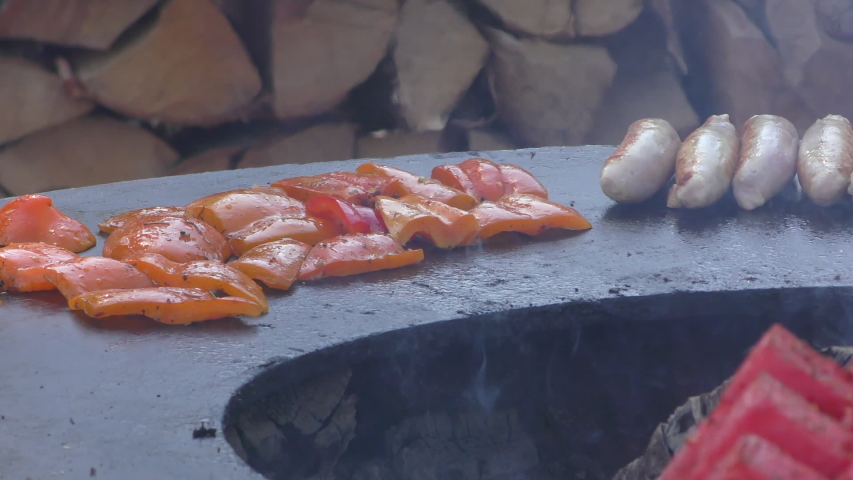 Cooking meat sausages on the open barbecue. BBQ festival in the Moscow park Sokolniki