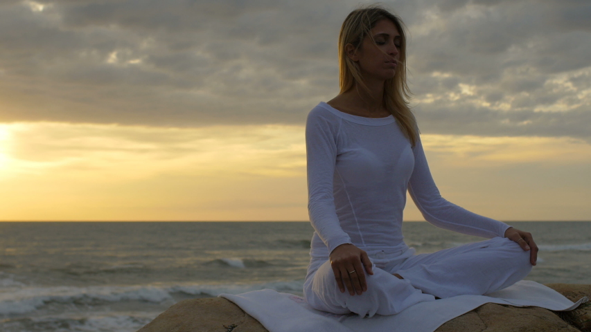 Blonde lady on the beach doing yoga