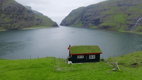 4K video (Ultra High Definition). Gloomy summer view of Saksun village with traditional turf-top house. Evening scene of Pollurin Laguna, Faroe Islands, Denmark, Europe. Traveling concept background.