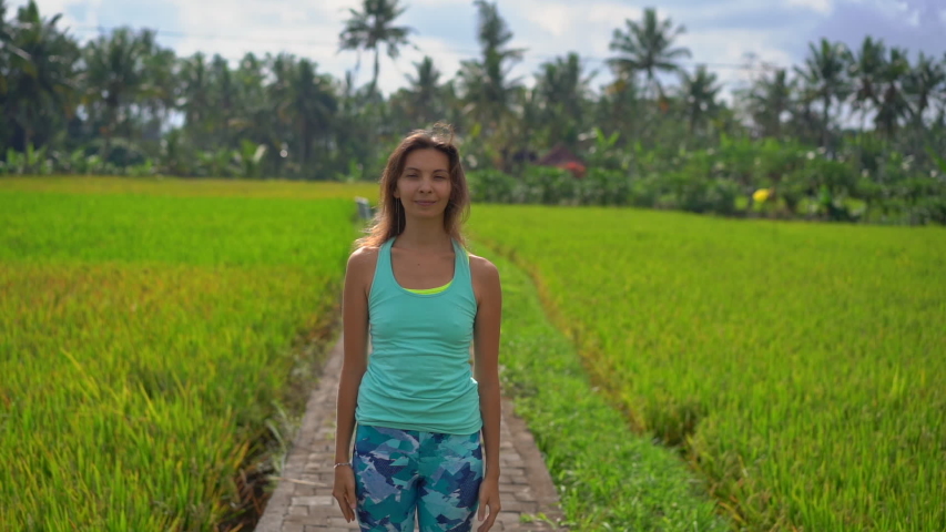 Slowmotion shot of a young woman practicing yoga on a beautiful rice field