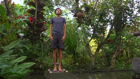 Slowmotion shot of a young man that using a Sadhu board or a nail board in a tropical surrounding