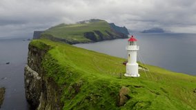 4k point of view video (Ultra High Definition) of old lighthouse on Mykines island. Beautiful morning view of Faroe Islands, Denmark, Europe. Dramatic seascape of Atlantic ocean.