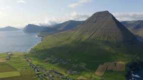 4K aerial - a bird's eye view video (Ultra High Definition). Sunny summer scene of Vidareidi village, Vidoy island. Amazing morning view of Faroe Islands, Kingdom of Denmark, Europe. 