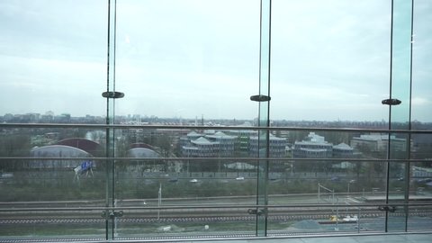 Traffic seen from glass building, tram passing