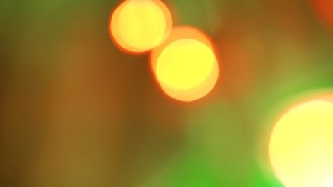 Colorful Christmas bokeh with blinking multicolored neon lights. Abstract blurred background with smoothly and sharply flickering New Year pink blue and green red lights. Flashing color footage 4K