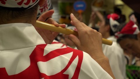 KOENJI, TOKYO, JAPAN - 24 AUGUST 2019 : Close up shot of blowing Japanese flute at AWA ODORI FESTIVAL (AWA DANCE FESTIVAL) in Koenji. Slow motion shot.