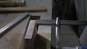 close-up, joiner making a dovetail on a wooden detail. A carpenter saws a wooden oak board with a hand saw .4k. 4k video. slow motion. 24 fps