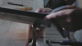 close-up, a carpenter sawing a wooden board with a hand saw. woodworker makes a dovetail on a wooden detail.4k. 4k video. slow motion. 24 fps