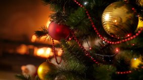 Closeup 4k video of glowing and glittering colorful lights on LED garland covering Christmas tree against burning fireplace. Perfect shot for winter celebrations and holidays - Powered by Shutterstock - Get 15% off with code: PIKWIZARD15