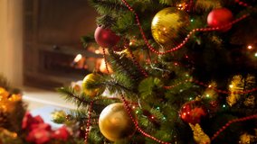 Closeup 4k video of glowing and blinking colorful led lights on Christmas tree against burning fireplace at night. Perfect shot for winter celebrations and holidays - Powered by Shutterstock - Get 15% off with code: PIKWIZARD15