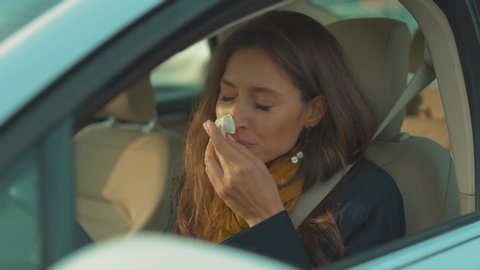 Young woman sitting in car feesneeze holds a handkerchief sick seat belt fastens vehicle influenza health illness flu medical sickness problem business infection headache slow motion