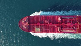 Aerial top down tracking video of industrial oil and fuel tanker cruising open ocean sea