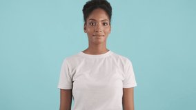 Portrait of cute african american girl joyfully looking in camera over blue background