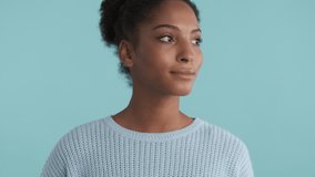 Portrait of smiling african american girl joyfully looking in camera over blue background