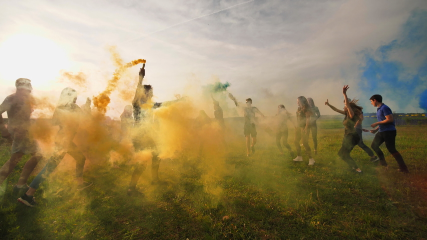 Happy friendly friends run across the field with toy planes that emit colored smoke. Royalty-Free Stock Footage #1037889725