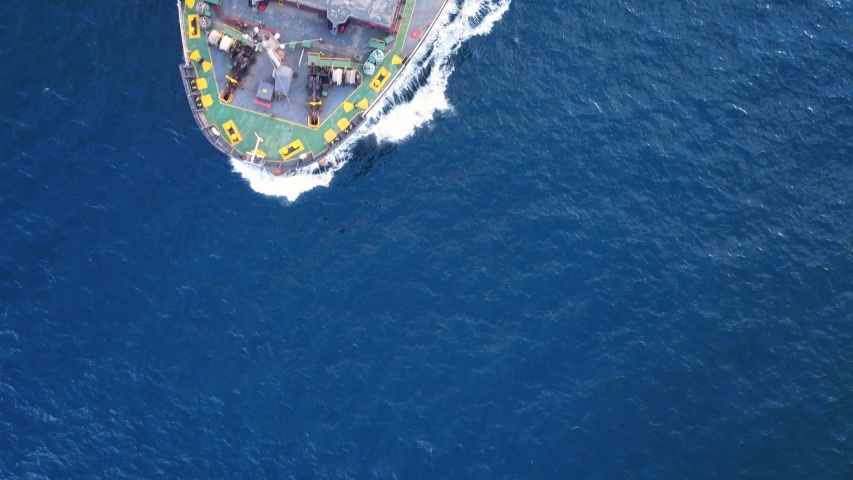 Aerial top down view. Flying over a bulk carrier ship underway. Bulkers are merchant ships, specially designed to transport unpackaged bulk cargo, such as grains, metal ores or coal
 Royalty-Free Stock Footage #1037890496