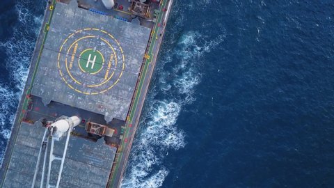 Aerial top down view. Flying over a bulk carrier ship underway. Bulkers are merchant ships, specially designed to transport unpackaged bulk cargo, such as grains, metal ores or coal
