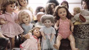 Antique ceramic dolls of different decades. Showcase of ceramic dolls in vintage store.4k - Powered by Shutterstock - Get 15% off with code: PIKWIZARD15