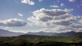 4k time lapse footage of clouds moving over green spanish landscape, shot in mountains close to marbella, malaga, spain, concept showing the passing of time on a sunny summer day