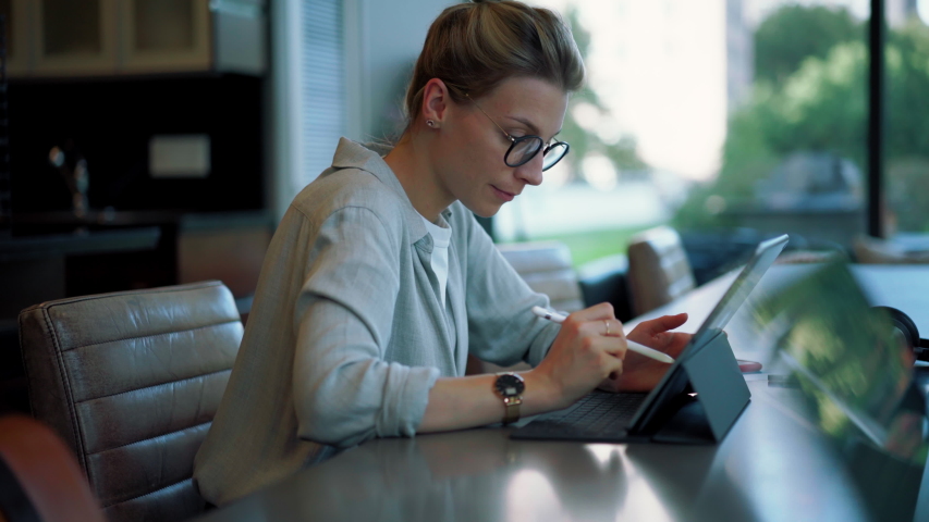 Attractive millennial woman enjoying online messaging on modern touch pad using 4g wireless connection for networking on websites, beautiful female in eyewear typing content text | Shutterstock HD Video #1037918294