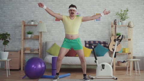 Expressive overweight man with a mustache and glasses funny dancing