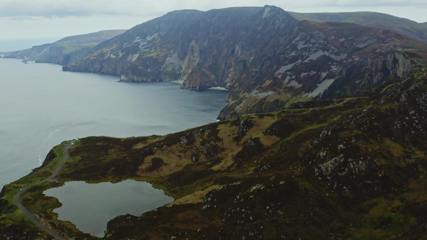 Aerial flying over road in Bunglass point and Slieve League impressive cliffs