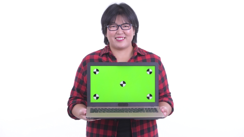 Happy overweight Asian hipster woman thinking while showing laptop