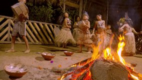aboriginal culture and art performing around fire of playing musical instruments and dancing in amazon jungle village in ecuador