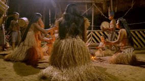 indigenous performing puja of fire and playing musical instrument traditional event in amazonian jungle at night in ecuador