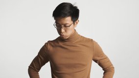 Young upset asian man taking off eyeglasses tiredly isolated