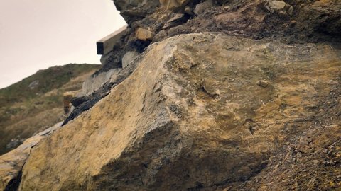 Slowmo, A piece of shale rock smashes against a boulder turns into small fragments.