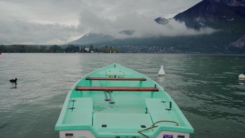 Nose of mint boat on the Lake Annecy against the background of fog mountains. Close up