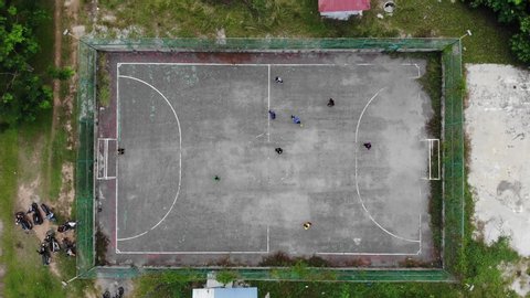 A group of teenagers playing Futsal at urban Futsal court in aerial view 4K