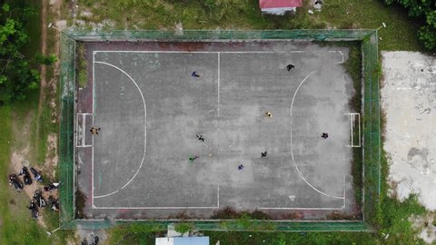 A group of teenagers playing Futsal at urban Futsal court in aerial view 4K