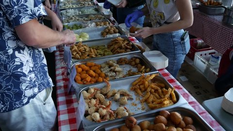 KRAKOW, POLAND - SEPTEMBER 15, 2019: A man chooses various Asian snacks at a food stall during Asian Food Festival in Krakow.
