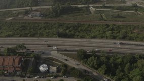 Aerial view of vehicles on a Malaysian highway in the morning. Panning to the right.