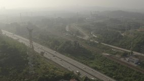 Aerial view of vehicles on a Malaysian highway in the morning. Tilt down footage.