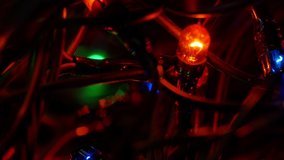 The diode bulb slowly gains brightness in the bundle of wires. 4K. Christmas garland. Red lantern. Macro. - Powered by Shutterstock - Get 15% off with code: PIKWIZARD15