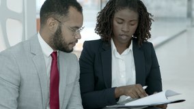 Business people signing contract. Professional young African American businessman and businesswoman working with papers in office. Paperwork concept