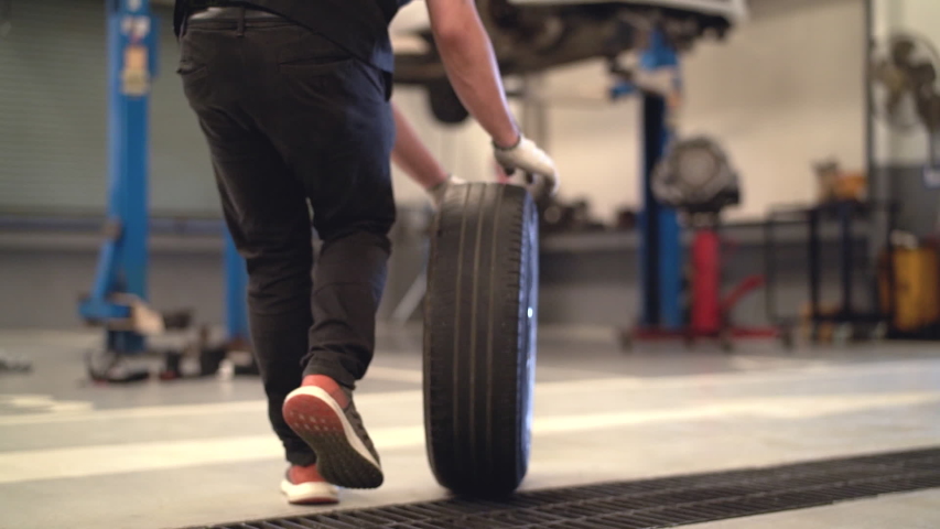 Mechanic man change a wheel tire and service maintenance the suspension of a vehicle , Safety inspection test engine before customer drive a car on a long journey, transportation service | Shutterstock HD Video #1038058385
