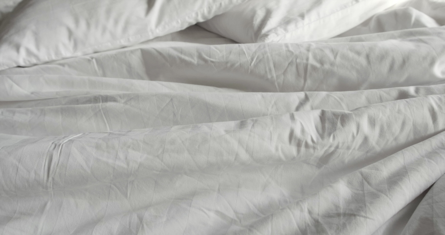 Truck shot of crumpled messy white blanket untidy with two pillow on the bed | Shutterstock HD Video #1038061868