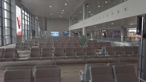 Many seats at empty airport terminal waiting area. No people in lounge at evacuated airport. Low season means poor business for air travel. Airport abandoned after terrorist attack.