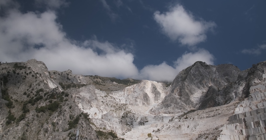 Carrara, Tuscany, Italy. Panorama of a white Carrara marble quarry in Tuscany. Mountains of the Apuan Alps, blue sky.