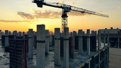 Project site with crane and high-rise buildings at sunset