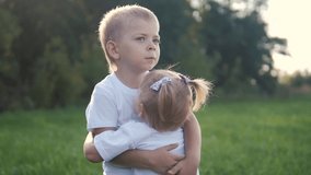 Happy family: little kid boy hugs circling embrace a and girl brother and sister hold hand on nature lifestyle happy children concept. children happy family boy hugs girl slow motion video. kids