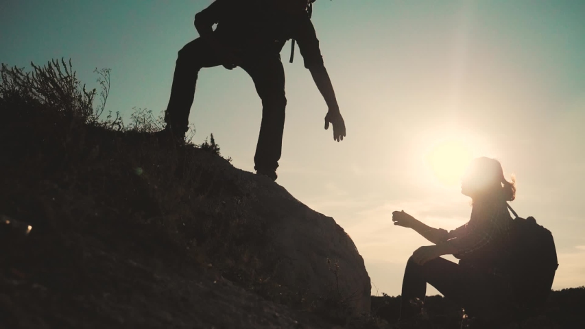Teamwork help business travel. silhouette slow motion video concept. Helping hand silhouette between two climbers. teamwork group of tourists lends helping hand climb the cliffs mountains. couple man | Shutterstock HD Video #1038089501
